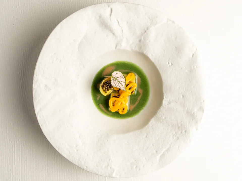 Plato de puerros a la brasa con yema, caviar y salsa verde