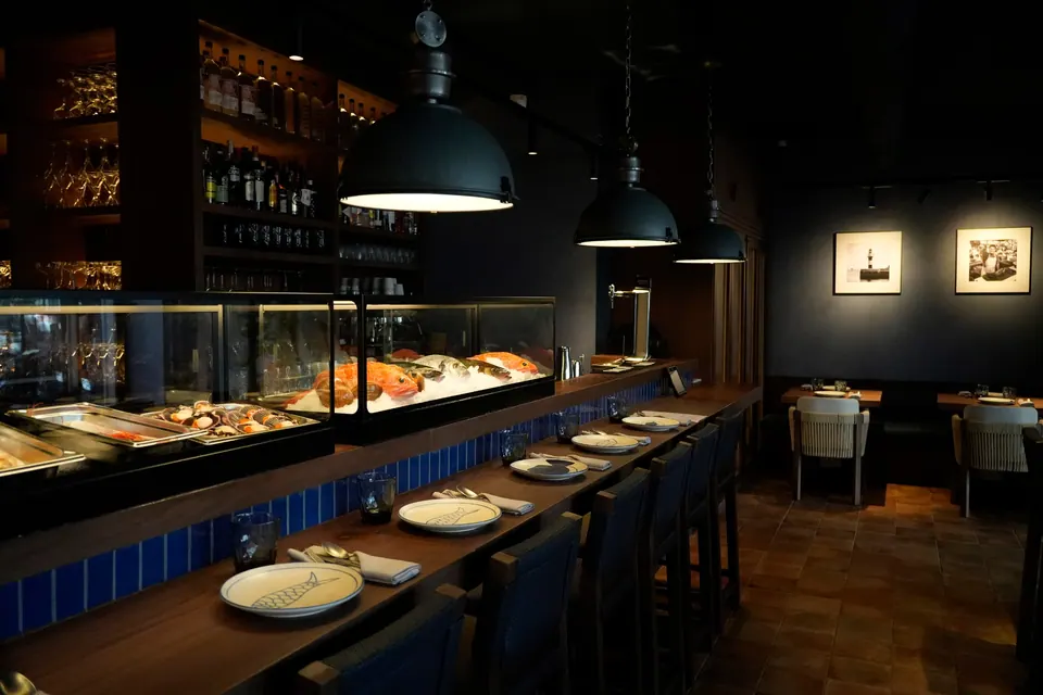 Barra marina de Chalaco con pescado fresco y mesas altas en Madrid