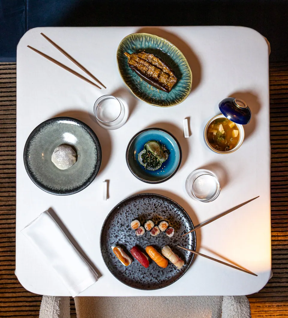 Vista cenital de mesa con sushi, miso, sunomono y berenjena dengaku