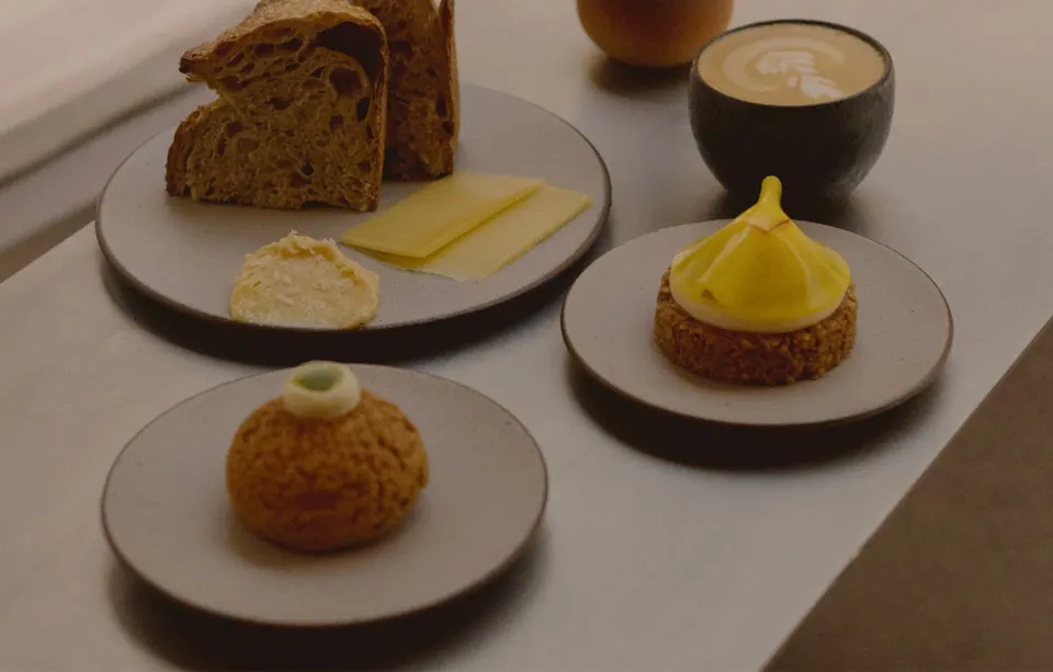 Mesa con pan, bollería, pastel y café en La Cabra Madrid