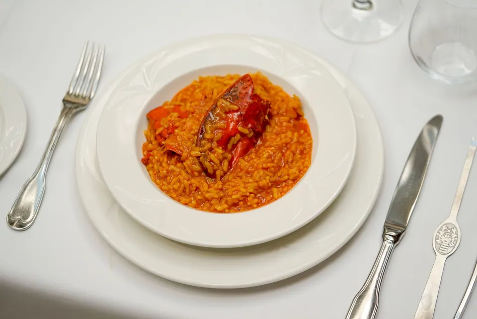 Arroz meloso servido en plato hondo sobre mantel blanco