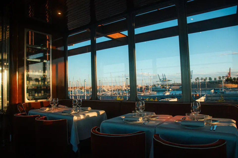 Comedor de MURO con vistas al puerto y mesas junto a ventanales