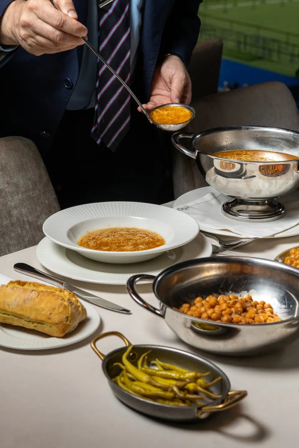 Servicio de sopa del cocido madrileño en una mesa de Puerta 57