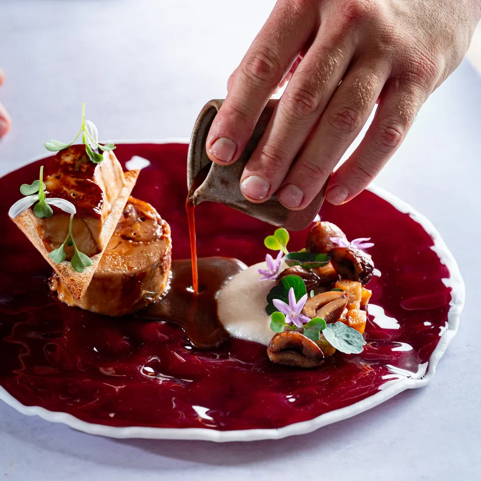 Emplatado de pintada Rossini con salsa servida en mesa