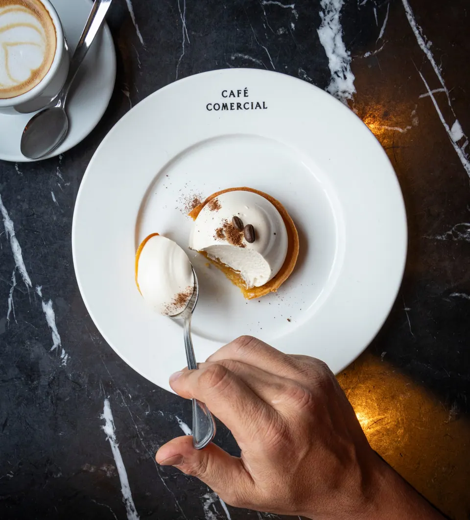 Porción de tarta de limón con café servida en Café Comercial